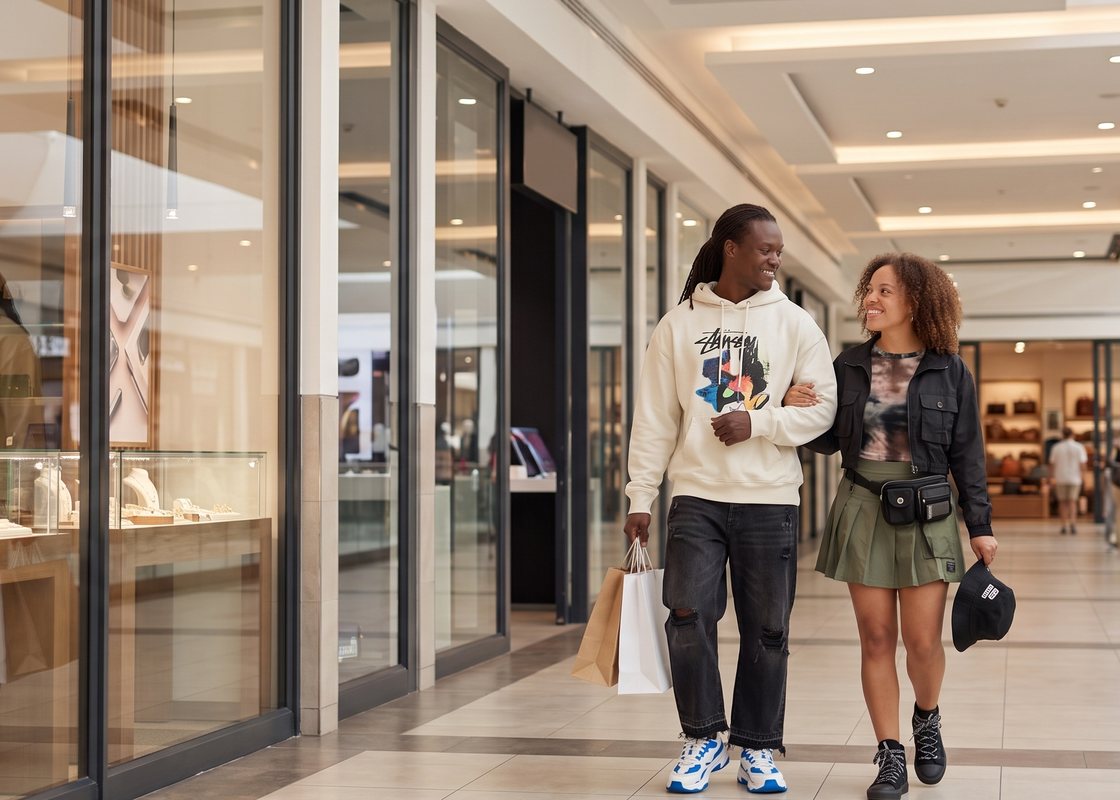 A couple walking through a mall carrying shopping bags
